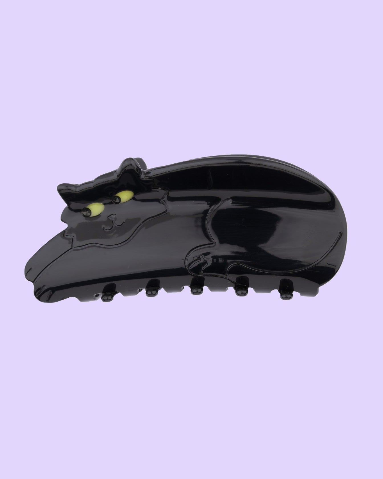 Black cat hair law with yellow eyes on a light purple background