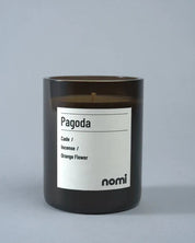 Candle labeled 'Pagoda' by nomi on a gray background