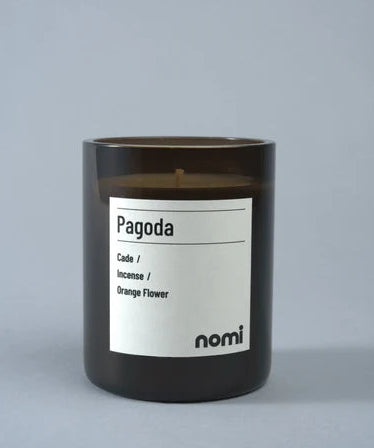 Candle labeled 'Pagoda' by nomi on a gray background