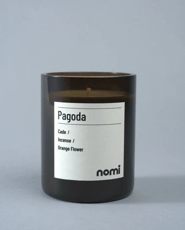 Candle labeled 'Pagoda' by nomi on a gray background