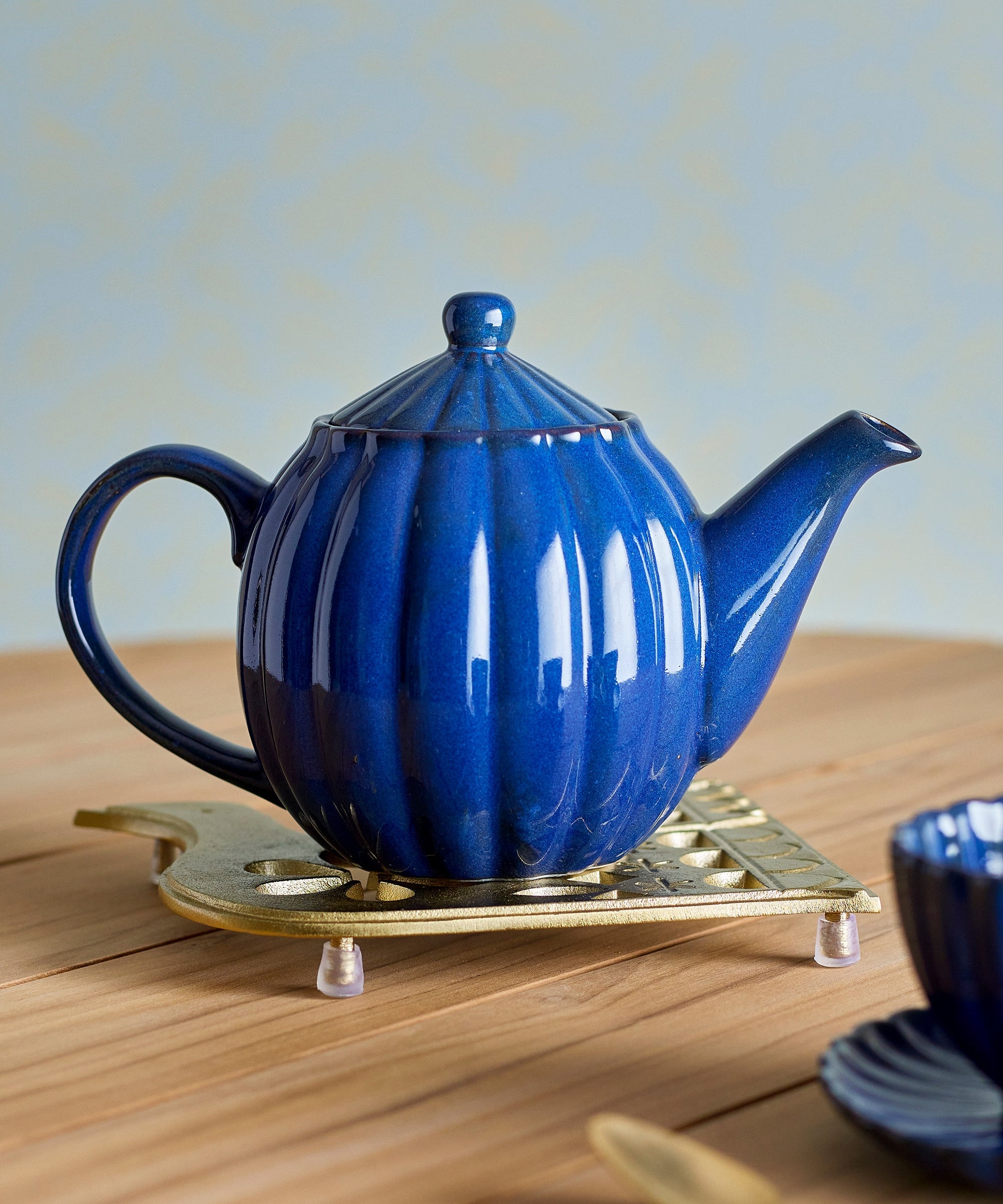 Blue teapot on a wooden surface with a light background