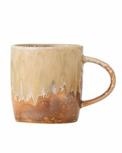 Beige ceramic mug with a textured surface on a white background