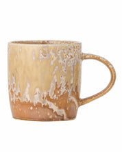 Brown ceramic mug with speckled pattern on a white background