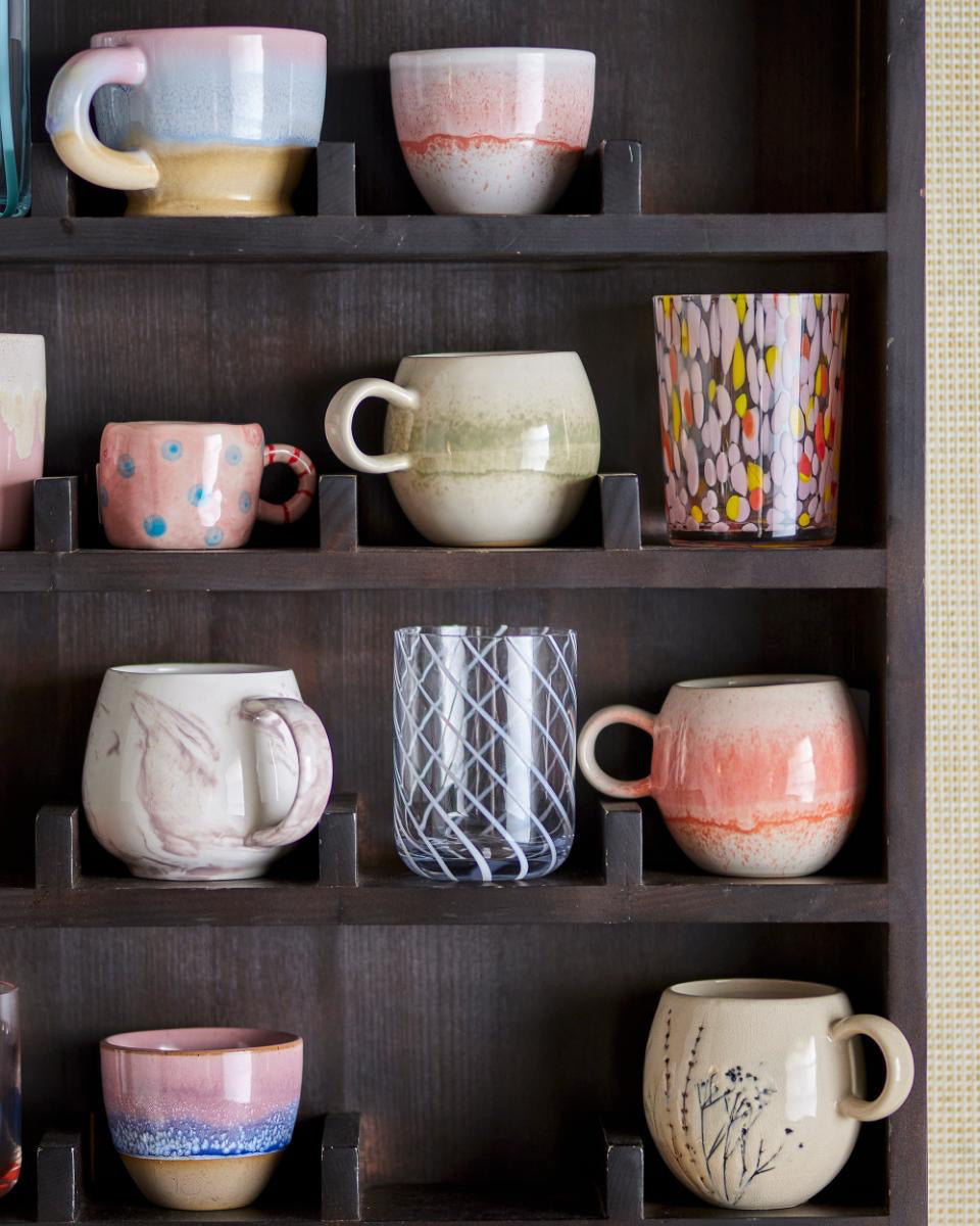 Collection of ceramic mugs on a dark wooden shelf