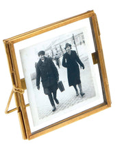 Gold picture frame with a black and white photo of two people on a street.