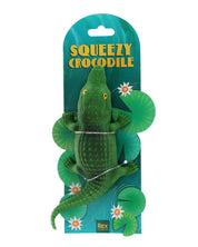 Green crocodile toy with packaging labeled 'Squeezy Crocodile' on a white background