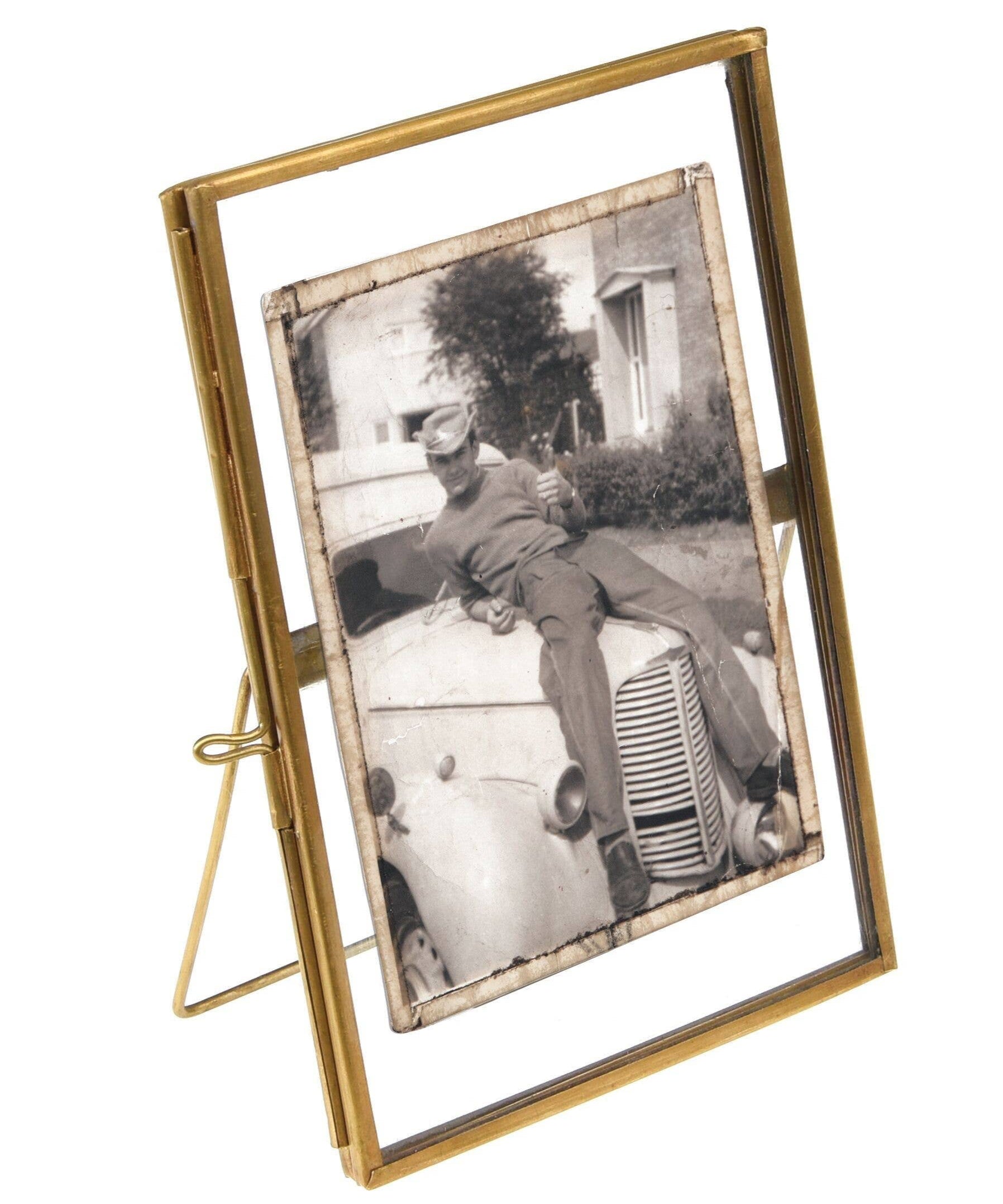 Gold photo frame with a black and white photo of a child on a car
