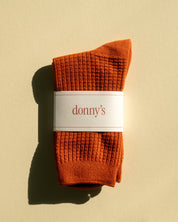 Waffle texture socks in rust colour folded in their original packaging
