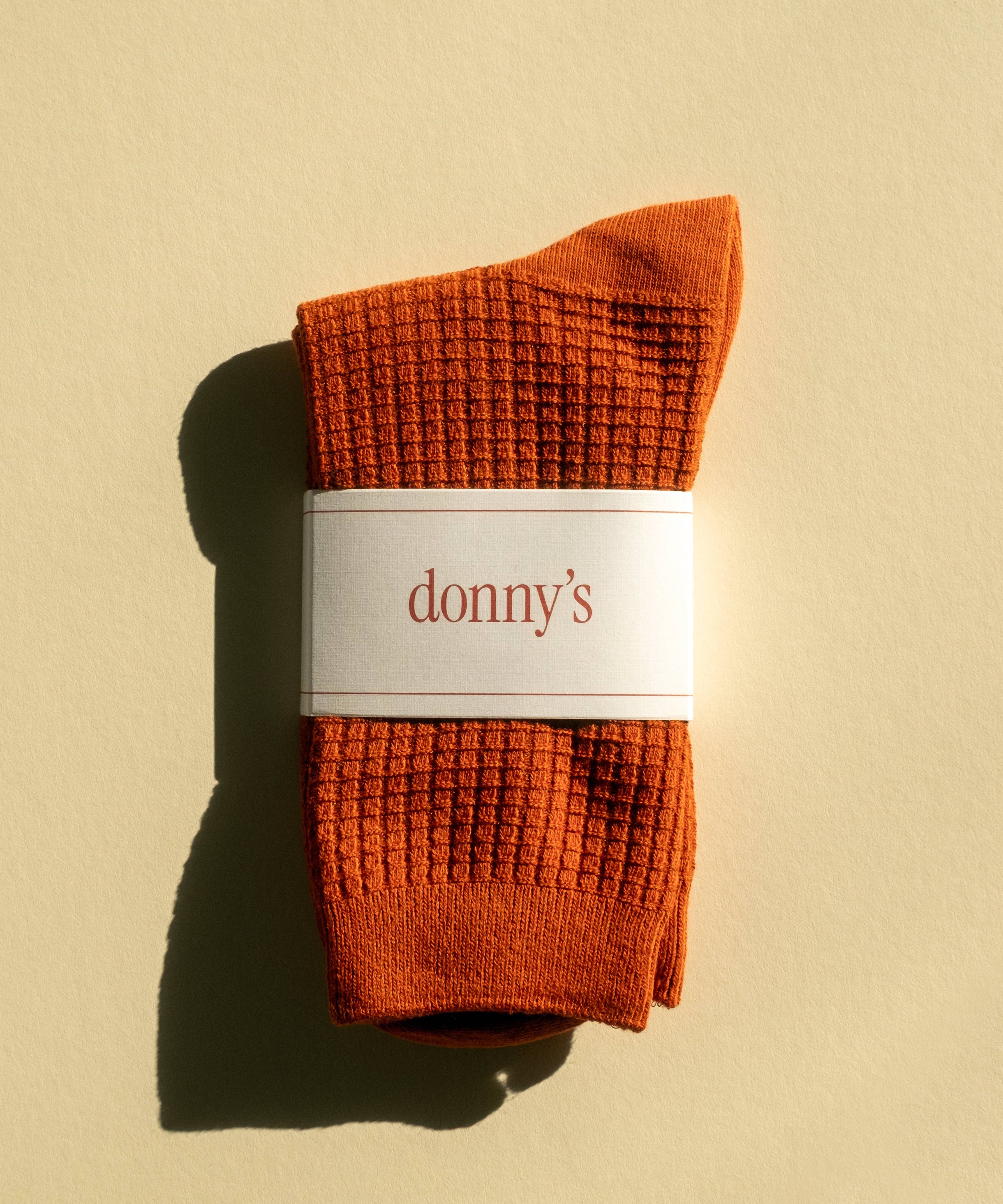 Waffle texture socks in rust colour folded in their original packaging