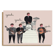 A square art print or card featuring an illustrated version of The Beatles, with the band members standing with their instruments on a pale pink background. The words 'yeah, yeah, yeah' appear in black script around them.