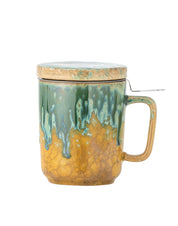 Ceramic mug with green and gold glaze on a white background