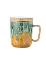 Ceramic mug with green and gold glaze on a white background