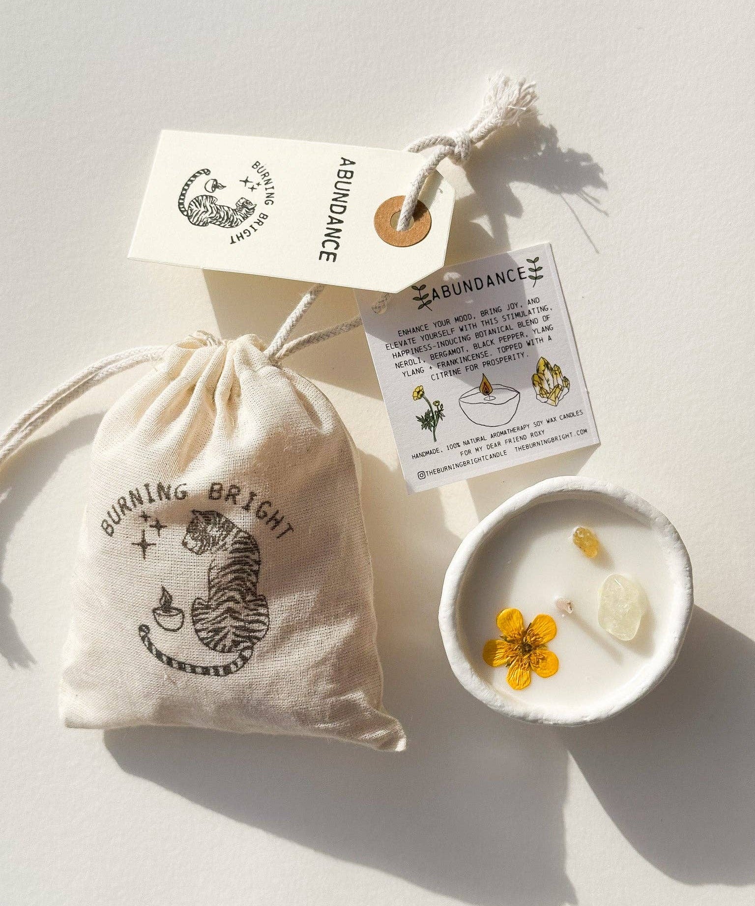 Burning Bright Abundance candle with citrine crystal and buttercup topping