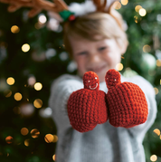 Child wearing red smiley face mittens on a string by EKA