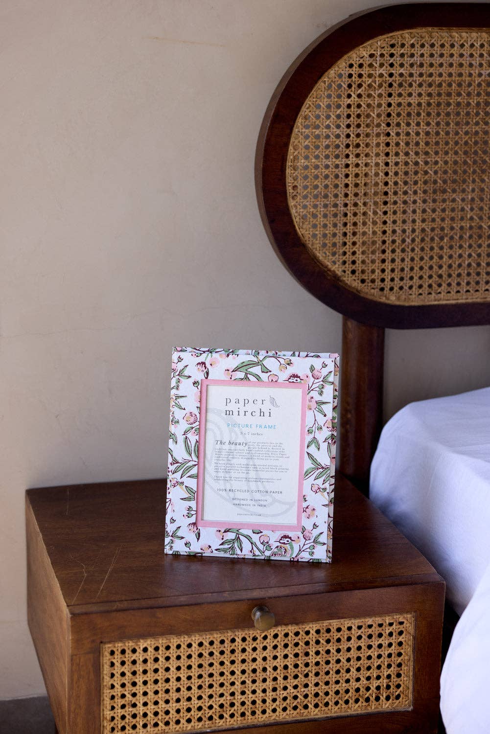 Floral patterned picture frame made from recycled cotton paper, sitting on a ned side table