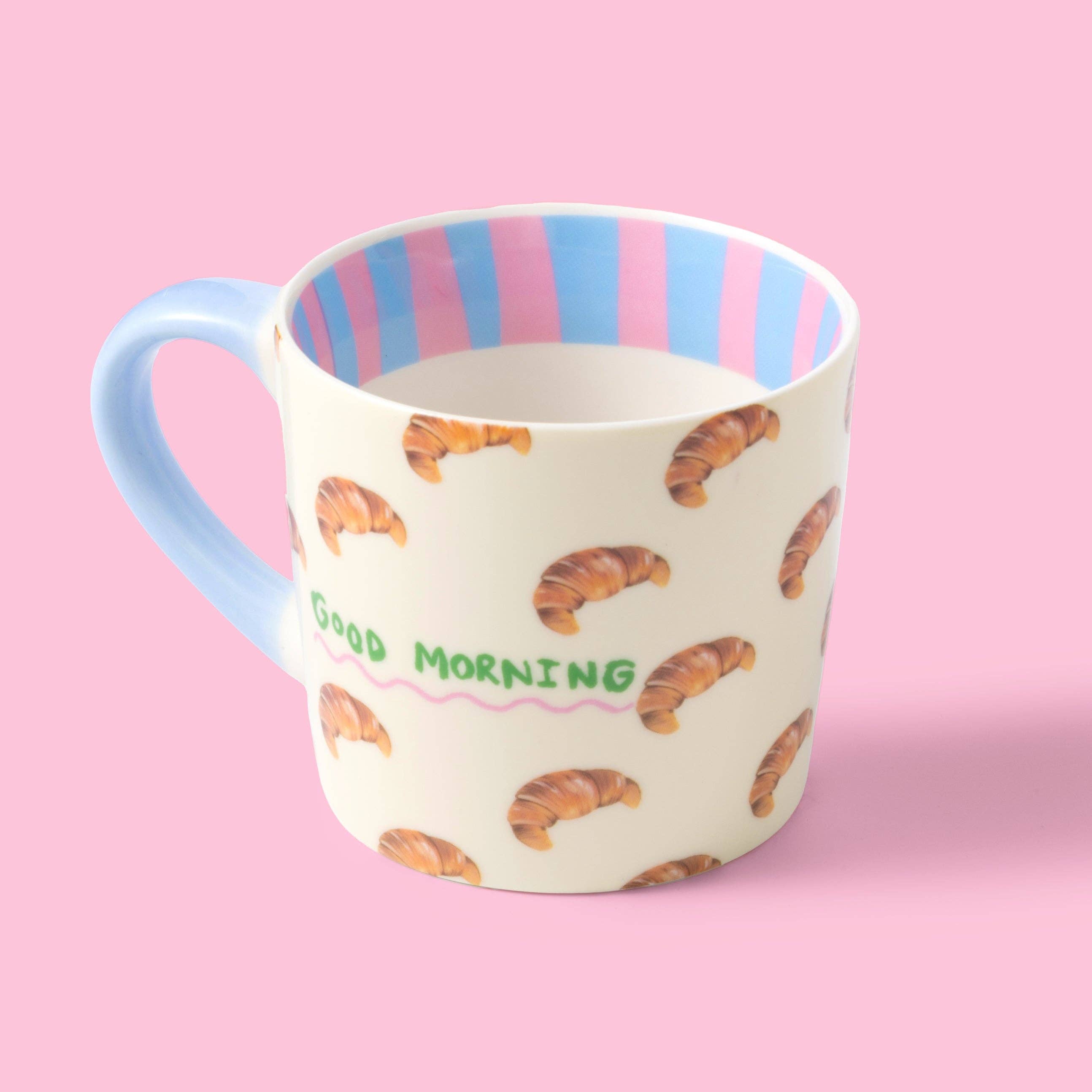 Mug with croissant pattern and 'Good Morning' text by Eleanor Bowmer, on a pink background