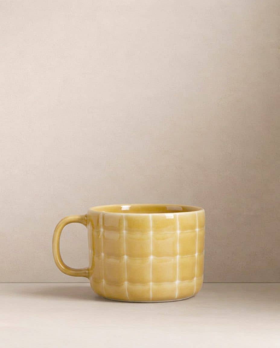 Egg Back Home yellow textured mug on a beige background