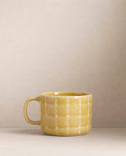 Egg Back Home yellow textured mug on a beige background