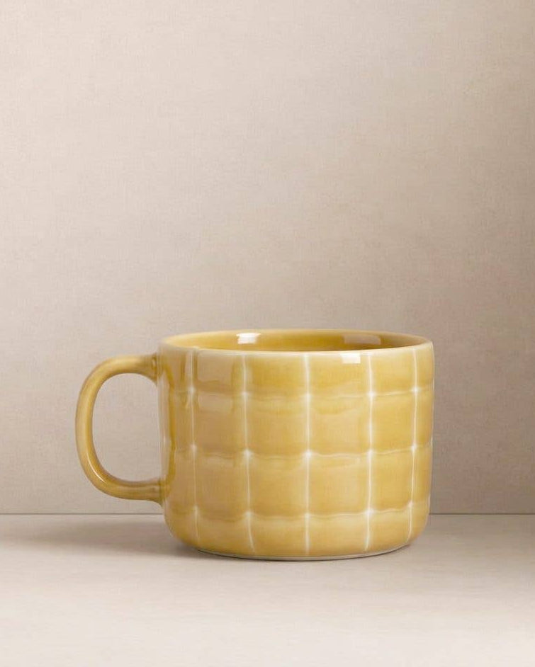 Egg Back Home yellow textured mug on a beige background