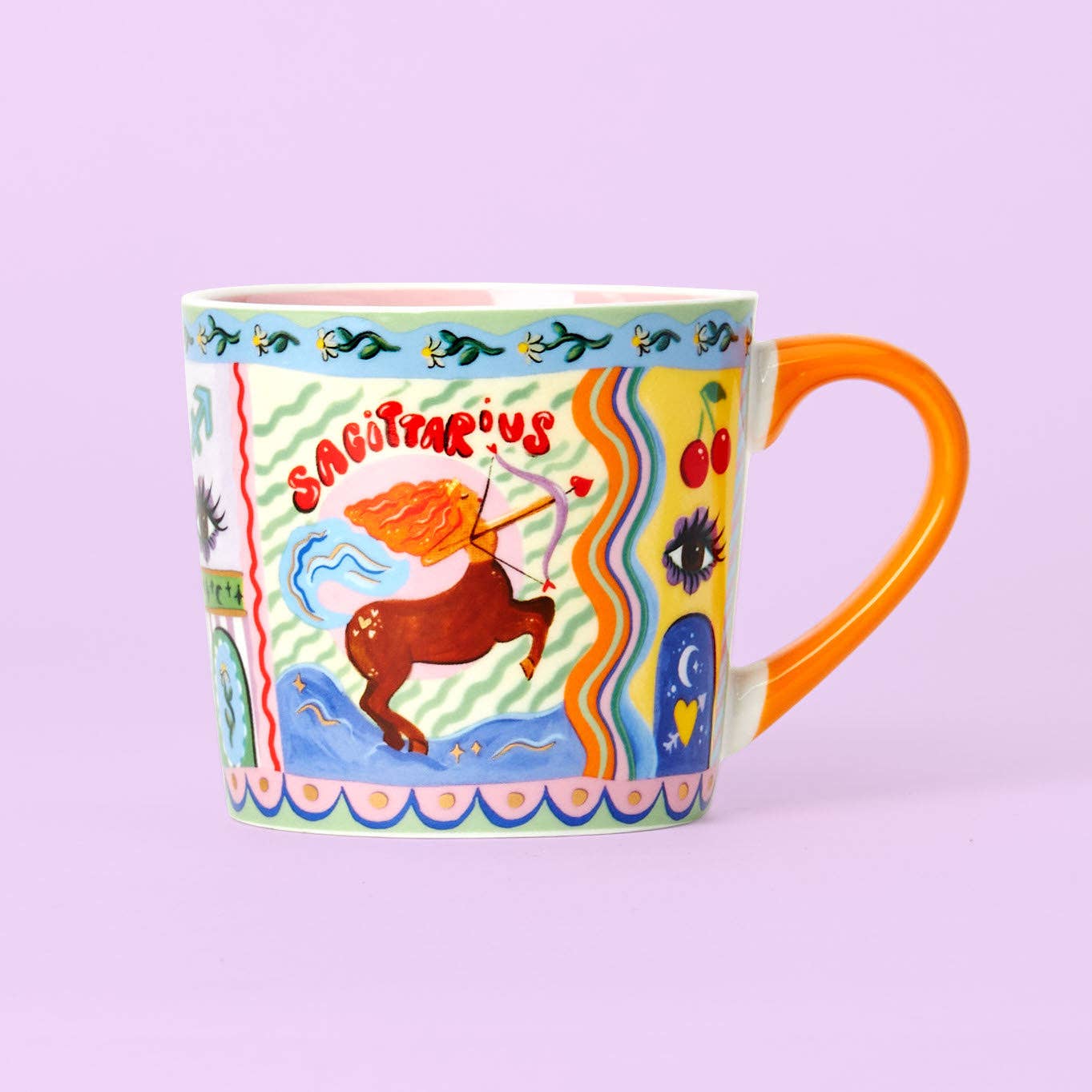 A colorful ceramic mug with Sagittarius zodiac sign illustrations and an orange handle.
