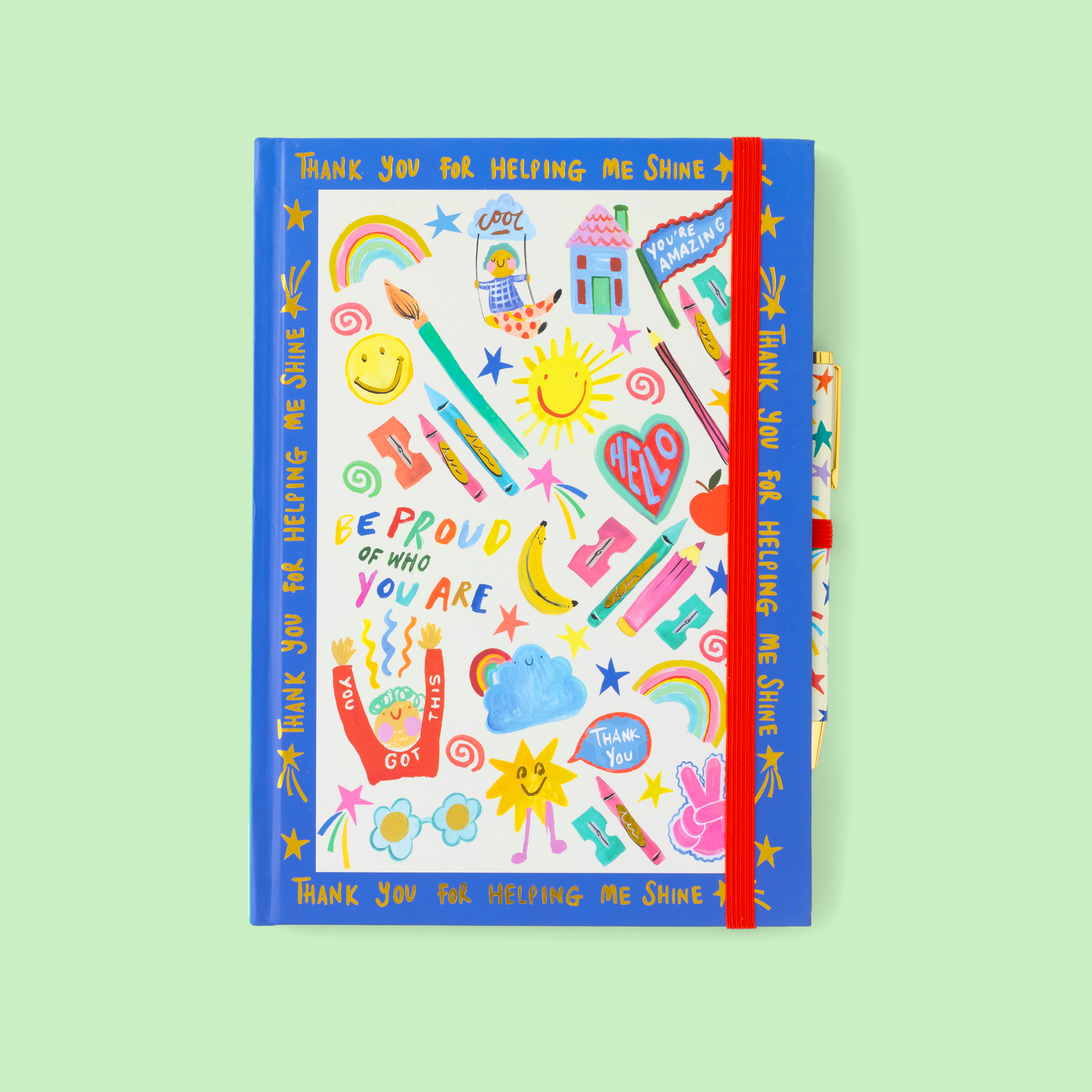 Colorful notebook with motivational illustrations, and a matching pen, on a light green background