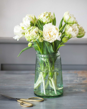 Clear vase with white flowers on a wooden surface