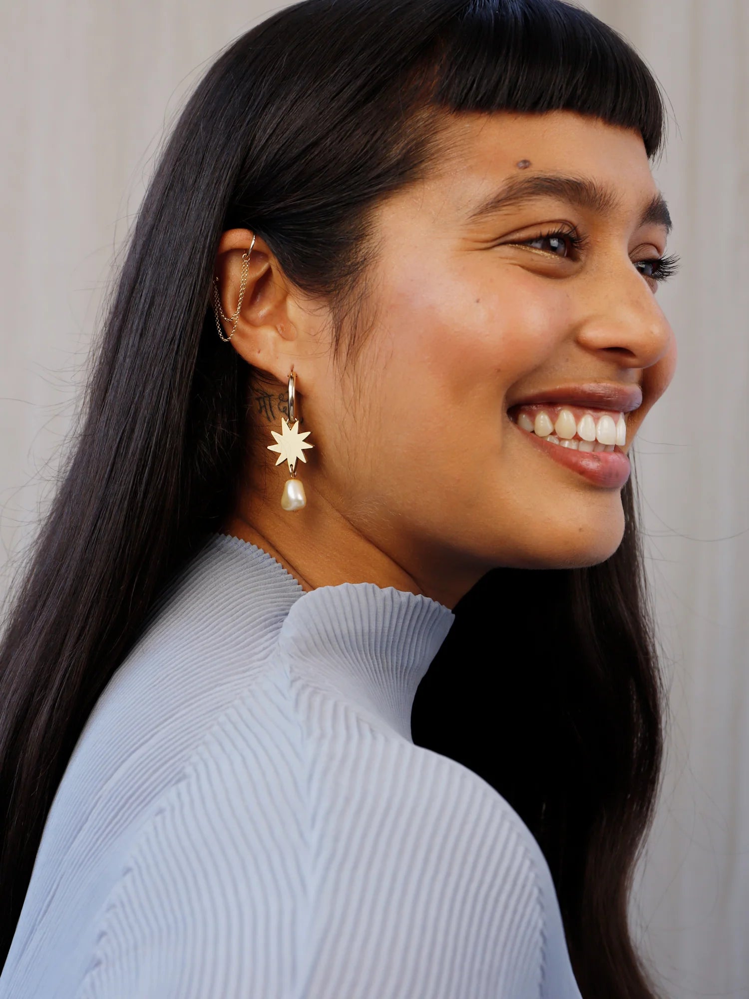 Kara hoop earring with star and pearl pendant from Wolf&Moon on model
