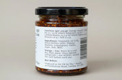 Jar with a label showing nutritional information and ingredients on a plain background
