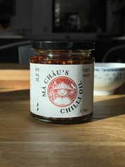 Jar of Mâ Cháu's Chilli Oil on a wooden surface