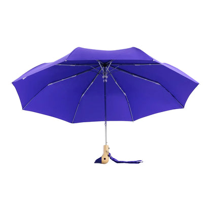 The Every Space compact, eco-friendly and lightweight, Royal Blue Umbrella, with 100% recycled, wind resistant fabric on a high-strength steel frame, sustainably sourced birch handle made from one solid piece of wood, and automatic open button, by Original Duckhead.