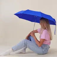 The Every Space compact, eco-friendly and lightweight, Royal Blue Umbrella, with 100% recycled, wind resistant fabric on a high-strength steel frame, sustainably sourced birch handle made from one solid piece of wood, and automatic open button, by Original Duckhead.