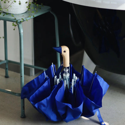 The Every Space compact, eco-friendly and lightweight, Royal Blue Umbrella, with 100% recycled, wind resistant fabric on a high-strength steel frame, sustainably sourced birch handle made from one solid piece of wood, and automatic open button, by Original Duckhead.