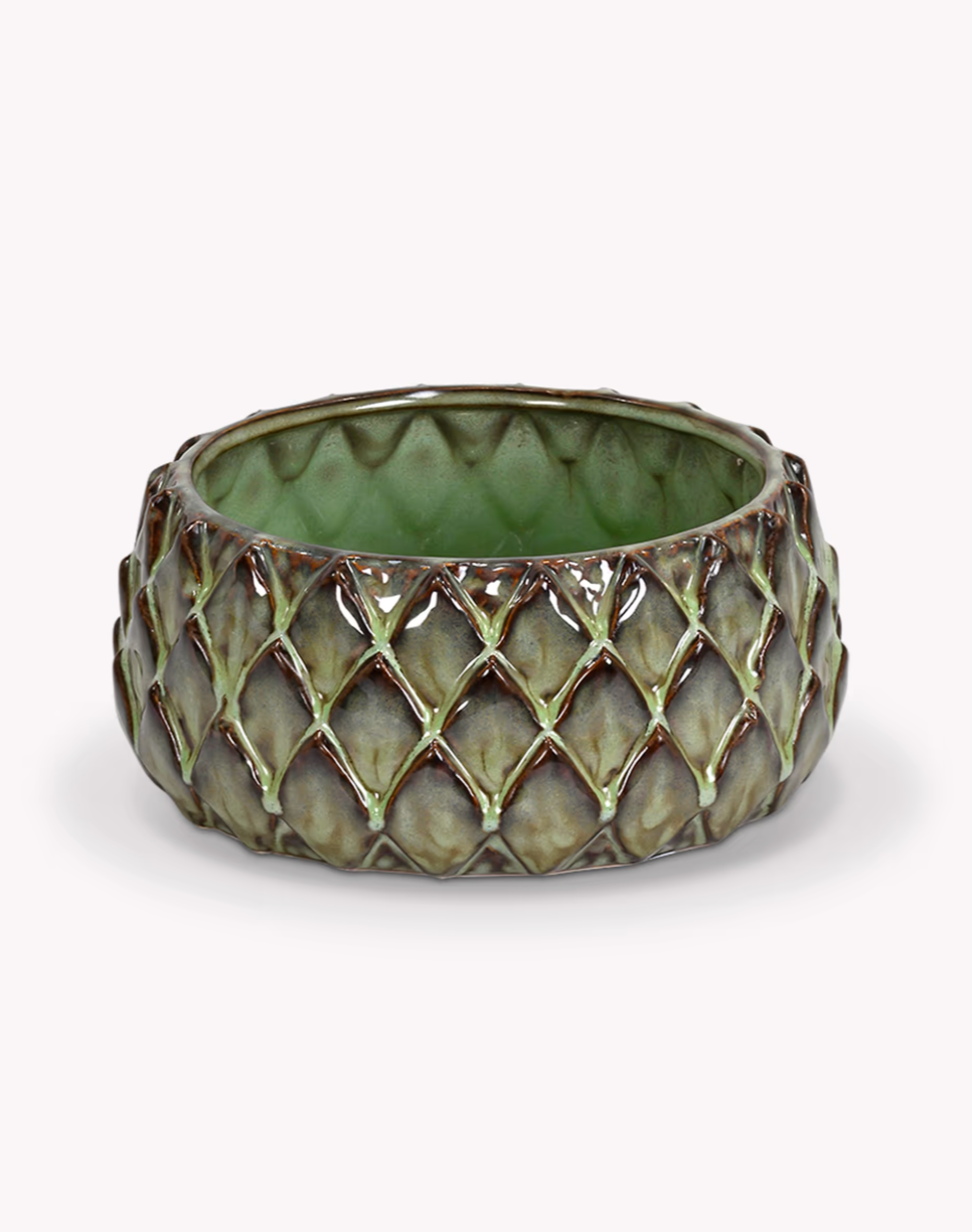 Decorative green candle holder with lattice design on a white background