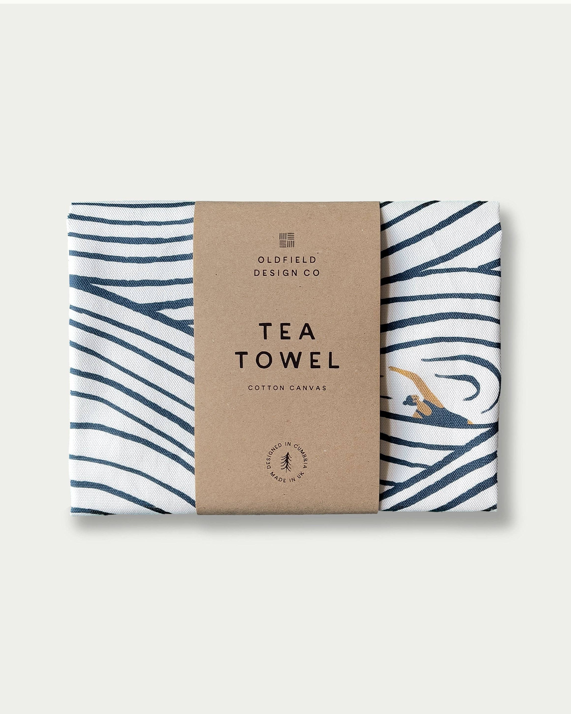 Tea towel with wavy blue pattern on a cardboard packaging labeled 'Oldfield Design Co' against a white background.