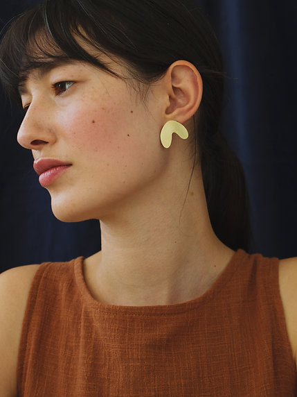 The Every Space Cassia studs in mirrored brass and sterling silver by Wolf & Moon