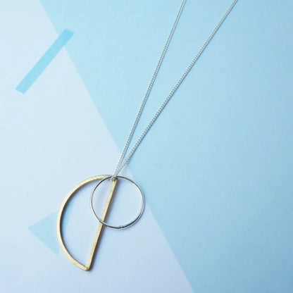 The Every Space Locus necklace with sterling silver chain, and brass and silver geometric charms by Custom Made UK