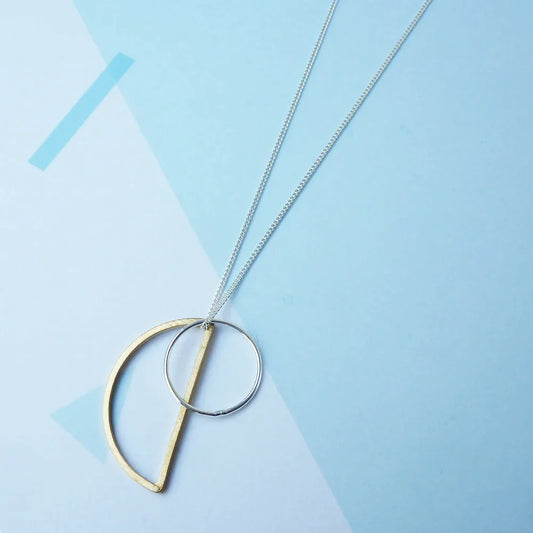 The Every Space Locus necklace with sterling silver chain, and brass and silver geometric charms by Custom Made UK