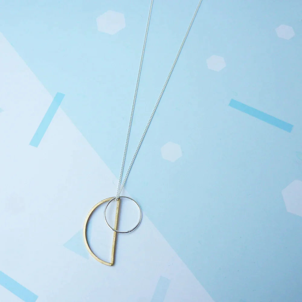 The Every Space Locus necklace with sterling silver chain, and brass and silver geometric charms by Custom Made UK