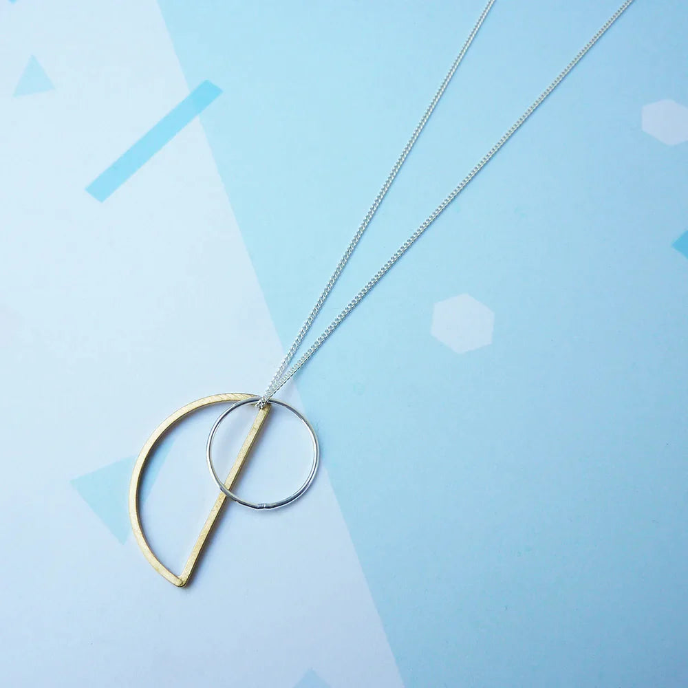 The Every Space Locus necklace with sterling silver chain, and brass and silver geometric charms by Custom Made UK