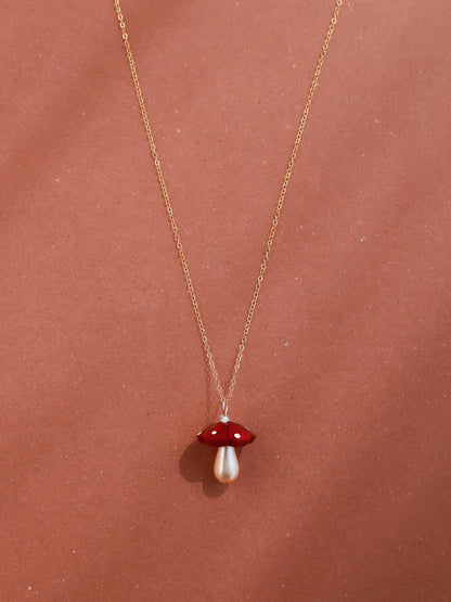 The Every Space Shroom necklace with gold filled chain and red marbled acrylic and glass pearly mushroom pendant by Wolf & Moon